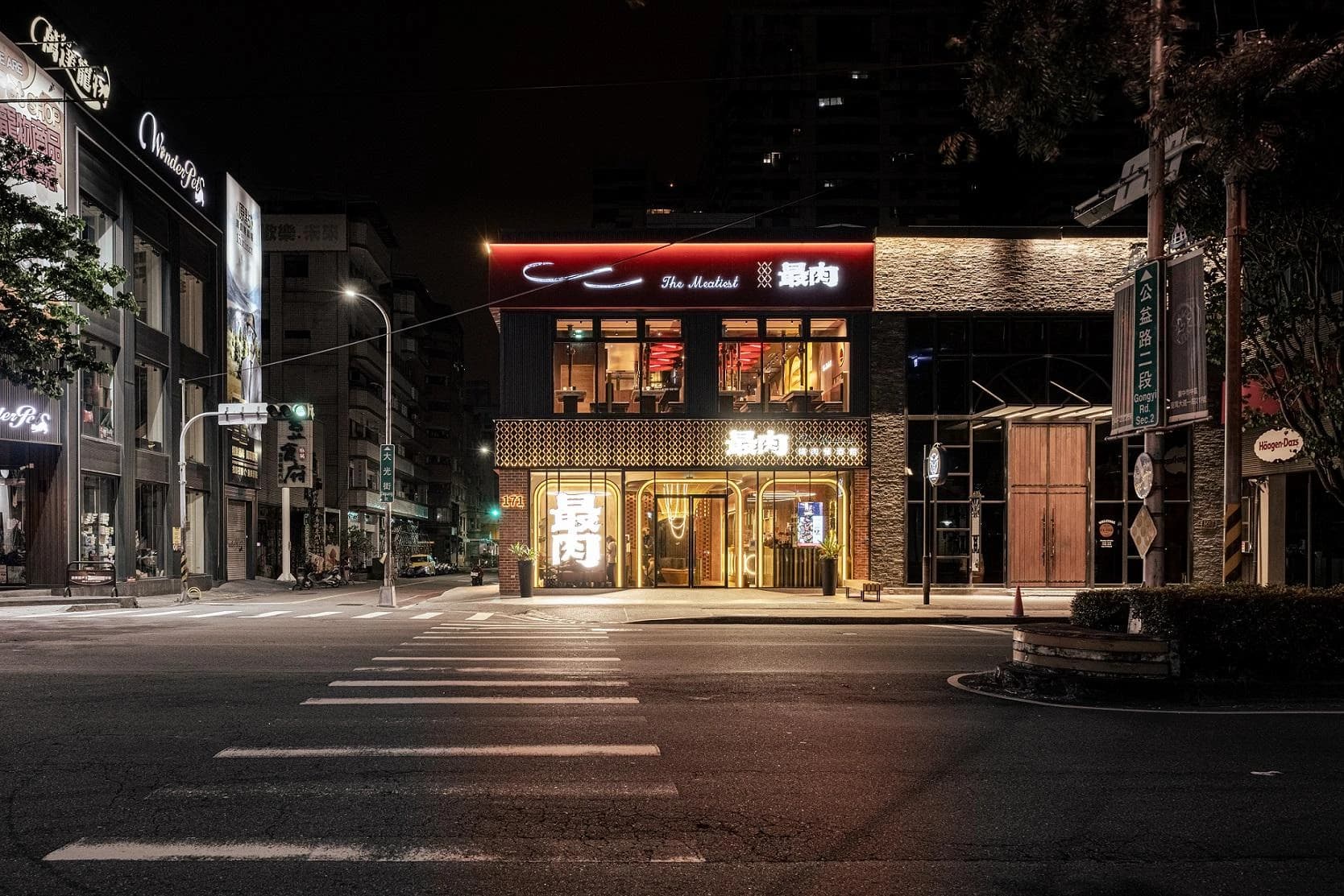 台中公益路最肉 THE MEATIEST 燒肉餐酒館建築外觀，以紅色招牌、菱形圖騰與連續拱形入口呼應肉、火花與火的品牌意象