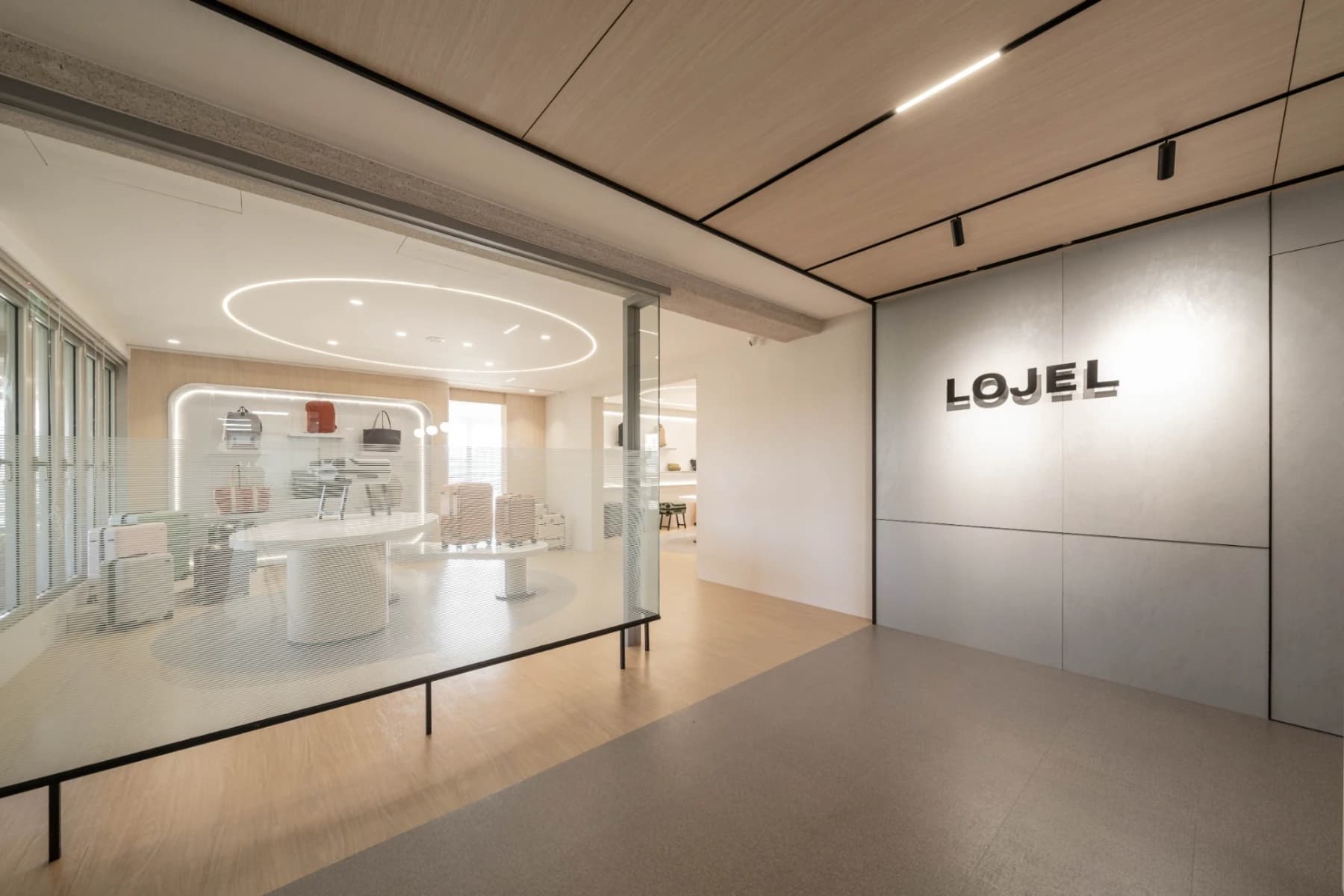 LOJEL 台灣總部精品迎賓入口，品牌牆與灰色暗紋美耐板牆面