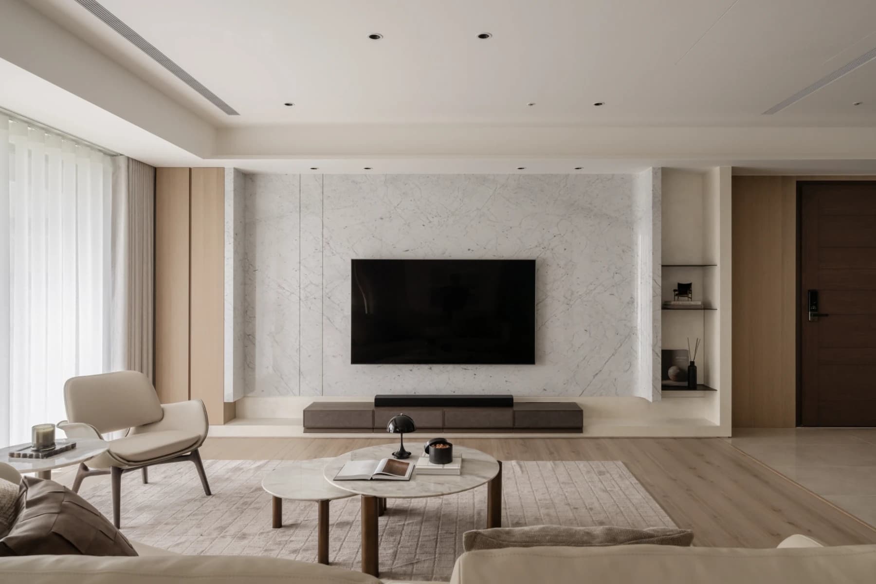 台中寶輝國際莊園 C.A. Residence 度假宅室內設計，客廳以白色紋理石材電視牆、木質地坪與開放式休憩空間呈現沉靜舒適的住宅氛圍